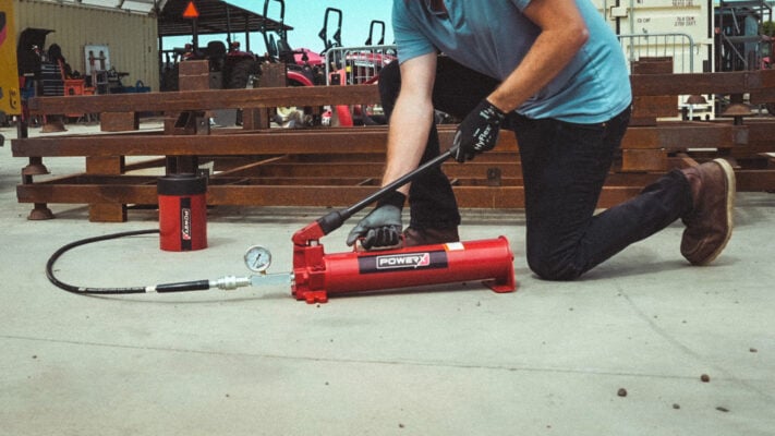 10,000 PSI Hydraulic Hand Pump in-action, extending a hydraulic cylinder in the field.
