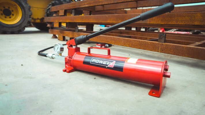 10,000 PSI Hydraulic Hand Pump in-action, extending a hydraulic cylinder in the field.